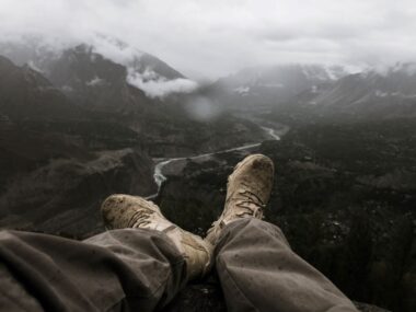 nogi i żółte buty trekkingowe na nich nad kanionem rzeki w górach